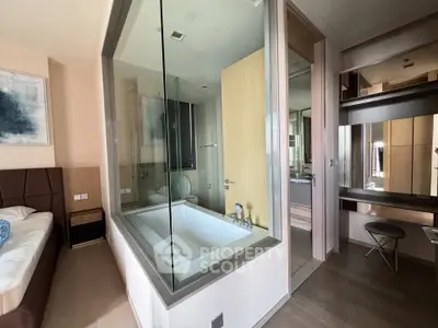 Modern bedroom with glass-enclosed bathtub and stylish decor