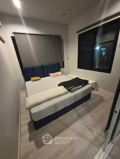 Cozy bedroom with modern decor and large windows for natural light.