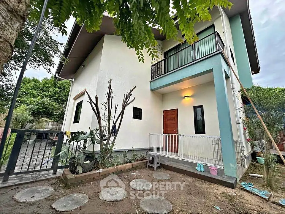 Charming two-story house with balcony and garden in a serene neighborhood.