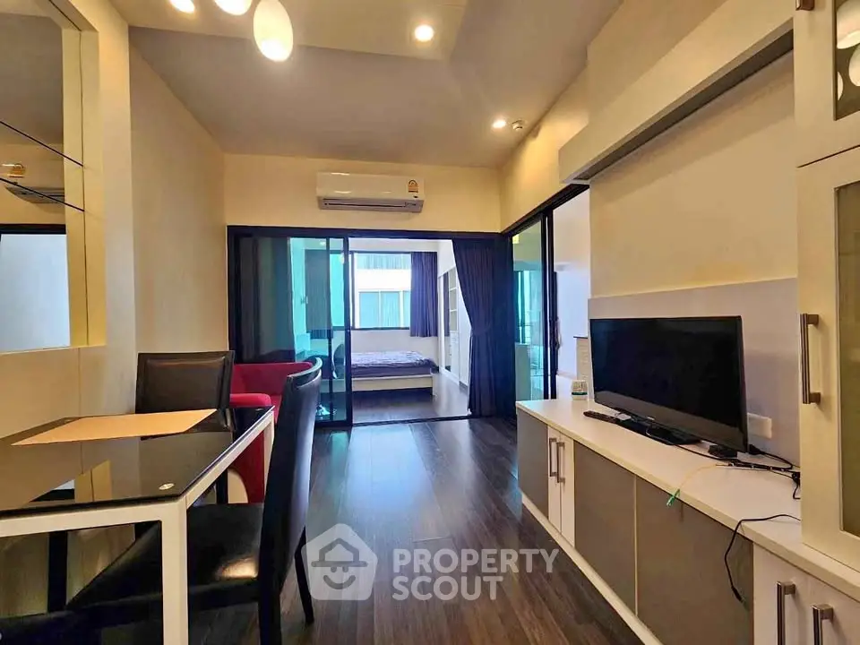 Modern apartment interior with open living room and bedroom view, featuring sleek furniture and stylish decor.