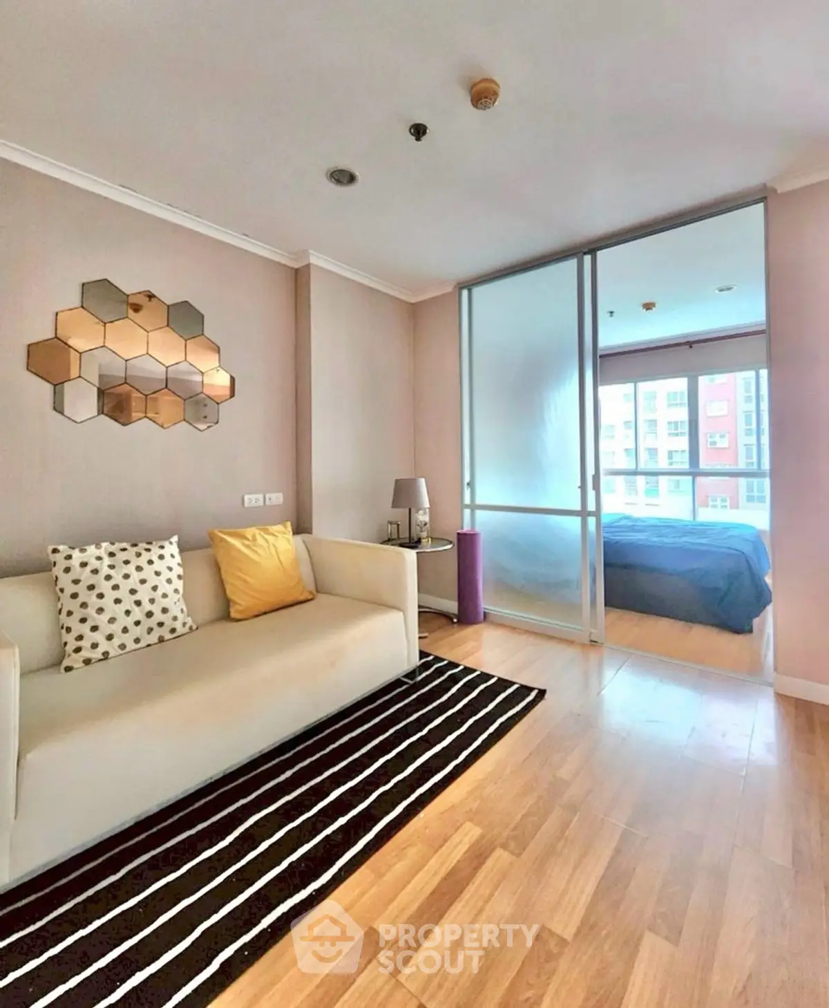 Modern living room with stylish decor and sliding glass doors to bedroom