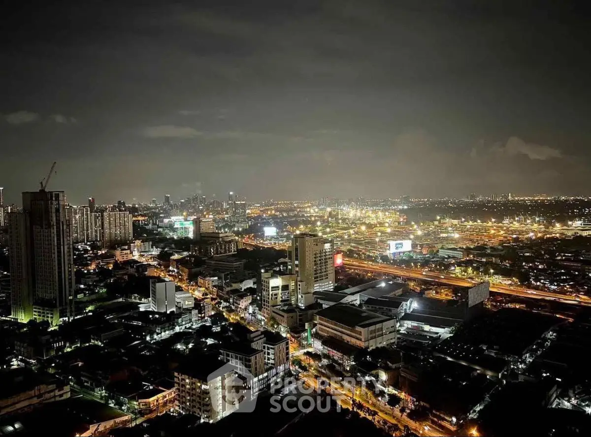Stunning cityscape view from high-rise building at night with vibrant lights.