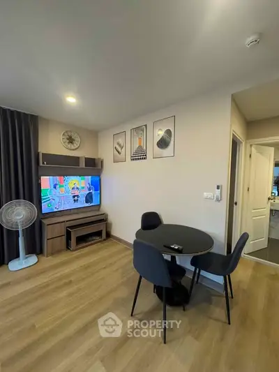Modern living room with wooden flooring, stylish furniture, and wall art, perfect for cozy gatherings.