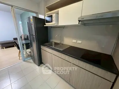 Modern kitchen with sleek cabinetry, stainless steel appliances, and open layout adjacent to dining area.