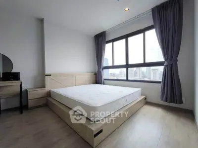 Spacious bedroom with large windows offering stunning city views, featuring modern furnishings and elegant decor.