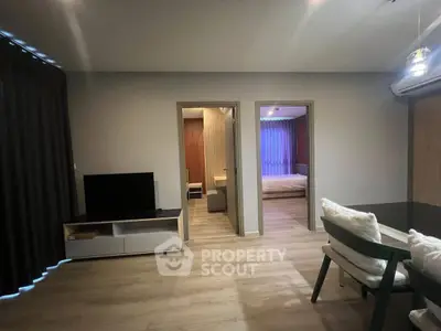 Modern apartment interior with open living and dining area, featuring stylish furniture and ambient lighting.