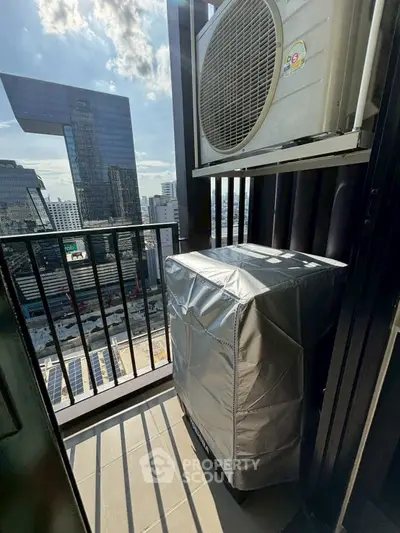 Modern balcony with city view and air conditioning unit in urban high-rise building.