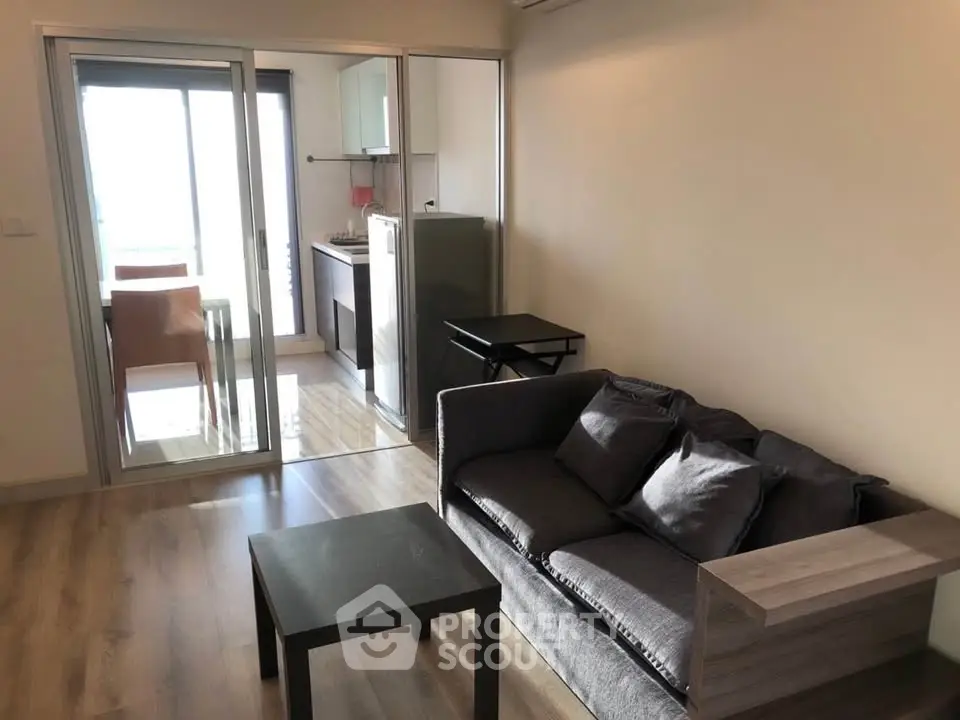 Modern living room with cozy sofa and open kitchen layout in a stylish apartment.