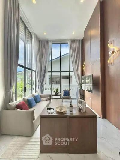 Luxurious high-ceiling living room with modern decor and large windows