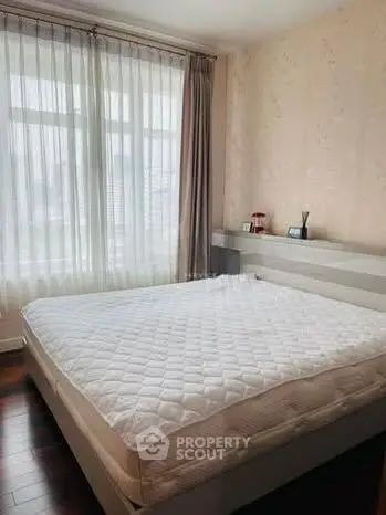 Spacious bedroom with large window and elegant decor