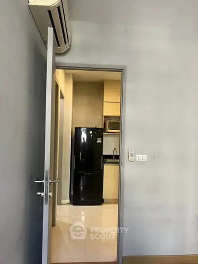 Modern apartment interior with sleek kitchen and air conditioning unit.