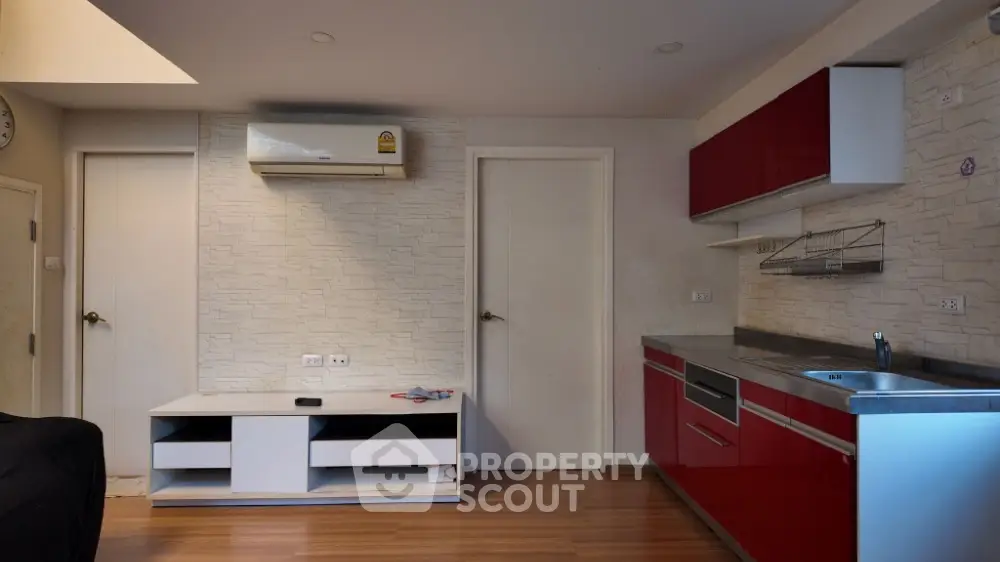 Modern kitchen with red cabinets and sleek design in a cozy apartment