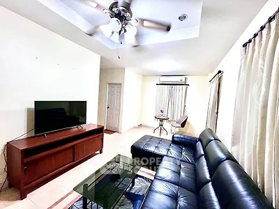 Spacious living room with modern leather sofa and ceiling fan