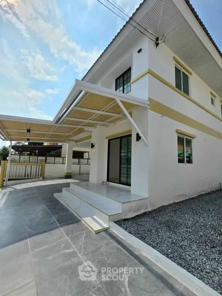 Modern two-story house with spacious driveway and sleek exterior design.