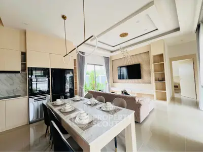 Luxurious open-plan kitchen and living room with modern decor and elegant dining area.
