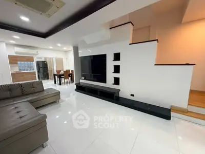 Spacious modern living room with sleek design and open dining area, perfect for family gatherings.