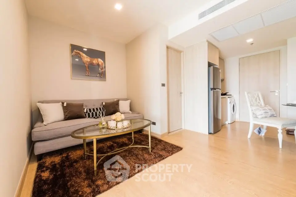 Modern living room with cozy sofa, stylish decor, and open kitchen layout in a bright apartment.