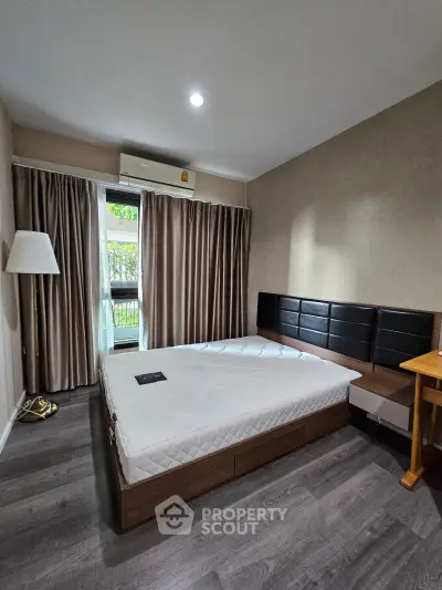Modern bedroom with stylish decor and natural light, featuring a comfortable bed and elegant flooring.