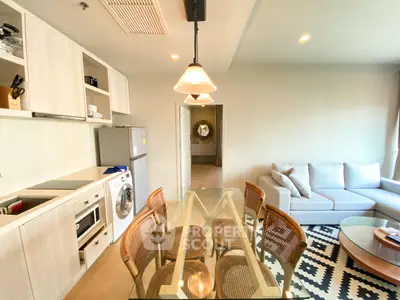 Modern open-layout kitchen and living room with stylish furniture and appliances.