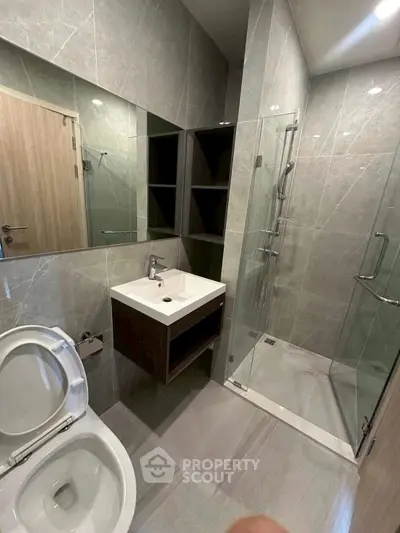 Modern bathroom with sleek design, glass shower, and elegant fixtures.