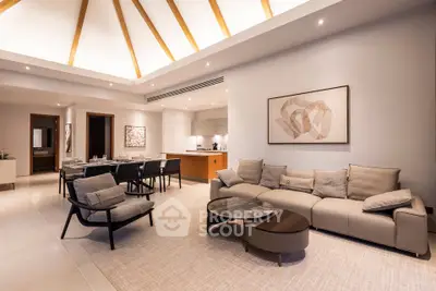 Luxurious modern living room with elegant furniture and open kitchen layout, perfect for entertaining.