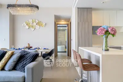 Luxurious open-plan living room with elegant dining area and modern kitchen, featuring chic decor and stylish lighting.