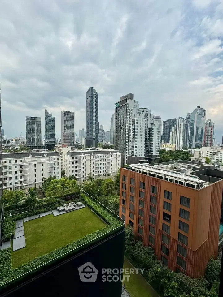 Stunning cityscape view from a high-rise building showcasing modern architecture and lush greenery.