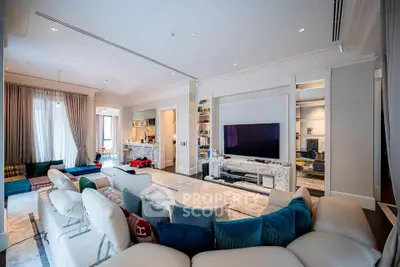 Luxurious and spacious living room with modern decor and large TV, perfect for entertainment and relaxation.