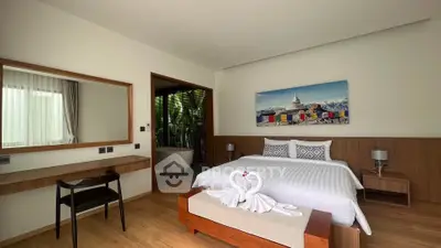 Luxurious bedroom with elegant decor and large window view, featuring a stylish desk and cozy seating area.