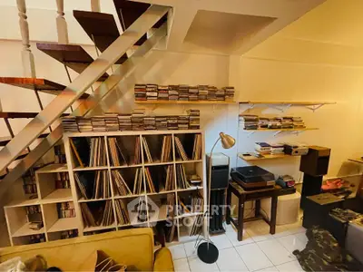 Charming living room with stylish staircase and extensive vinyl record collection.