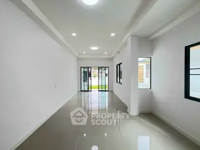 Spacious modern living room with large windows and glossy tiled floor