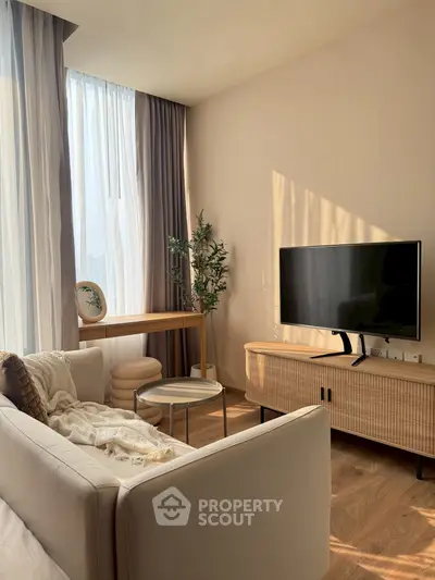 Modern living room with stylish furniture, large window, and natural light.