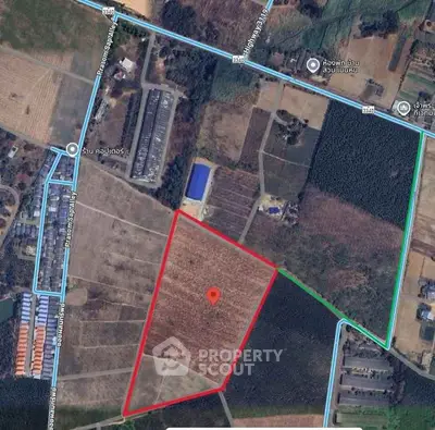 Aerial view of land plot with boundaries marked in red and blue lines.