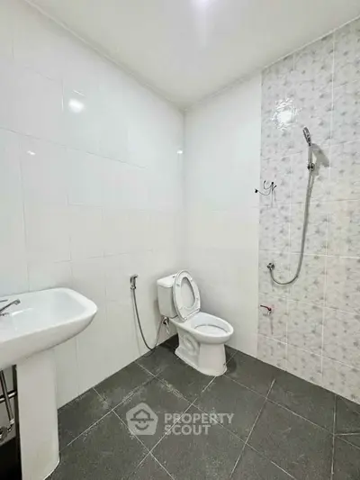 Modern bathroom with white tiles and sleek fixtures in a contemporary apartment.