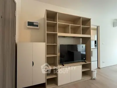 Modern living room with sleek TV unit and open shelving, perfect for stylish urban living.
