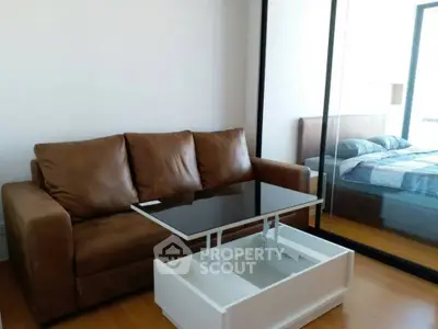Modern living room with brown leather sofa and sleek glass-top coffee table