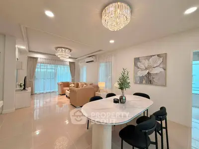 Luxurious open-plan living room with elegant chandeliers and modern decor