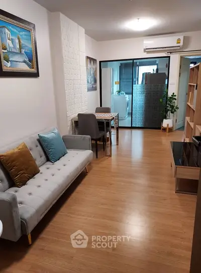Modern living room with stylish decor and open layout, featuring a cozy sofa and dining area.