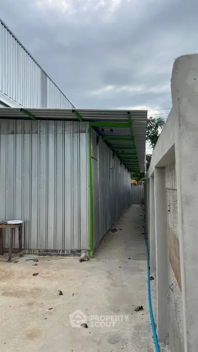 Industrial-style exterior with metal siding and concrete pathway, ideal for commercial use.