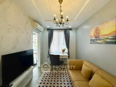 Charming living room with elegant chandelier and cozy seating area, perfect for relaxation and entertaining.