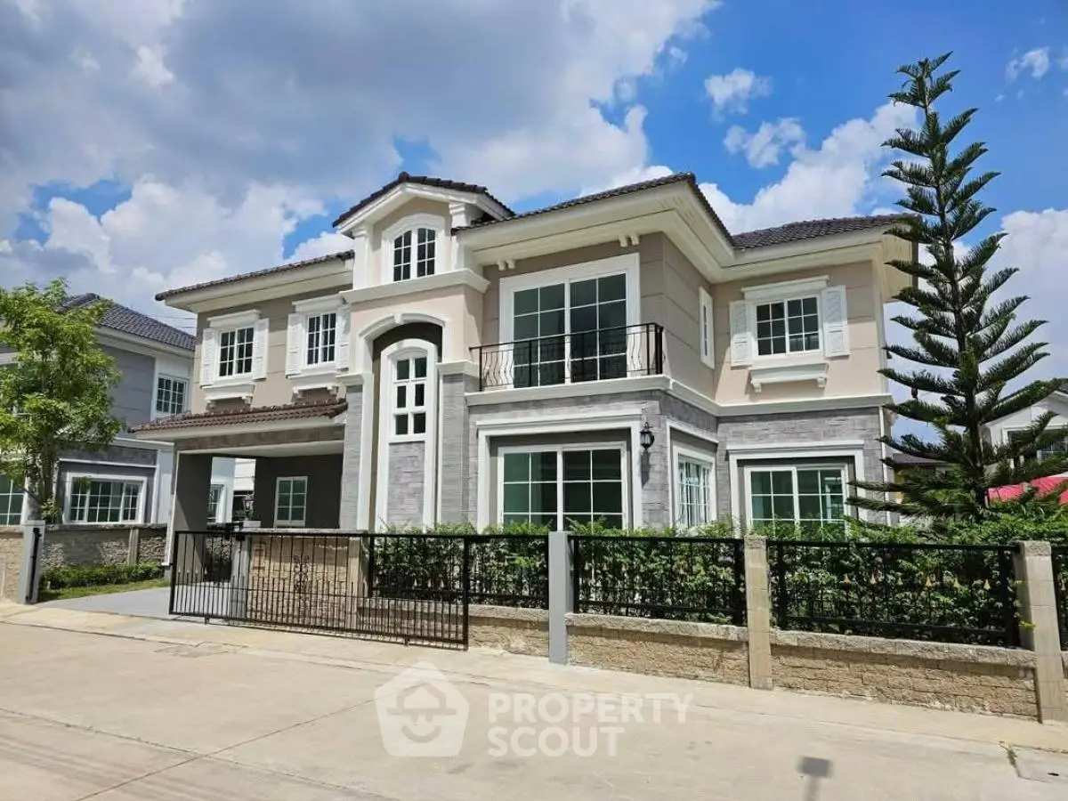 Stunning two-story house with elegant facade and lush landscaping under a bright blue sky.