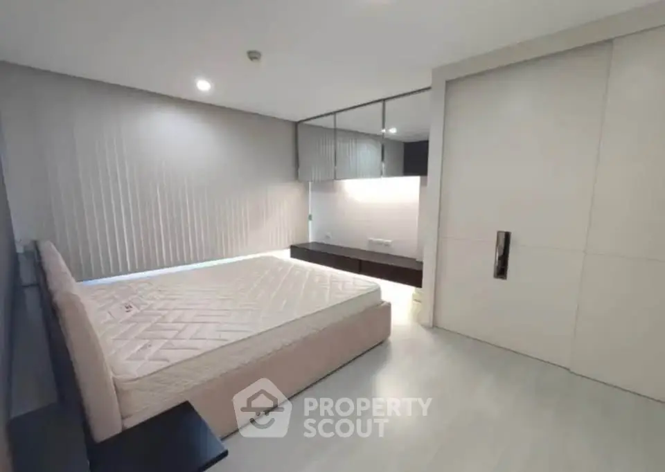 Modern minimalist bedroom with sleek design and ample natural light