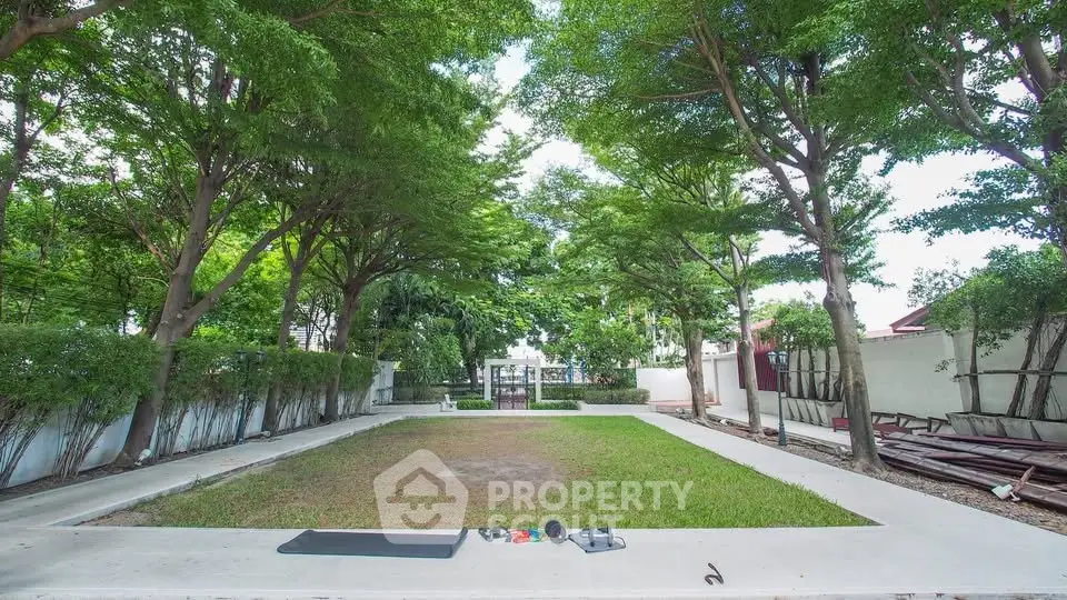 Spacious garden area with lush trees and open space, perfect for outdoor activities and relaxation.