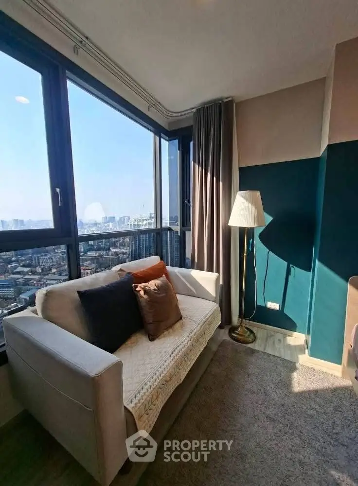 Cozy living room with city view, featuring a stylish sofa and floor lamp.