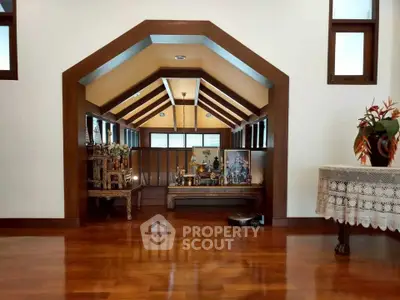 Elegant wooden interior with vaulted ceiling and polished floors, showcasing a serene and stylish living space.