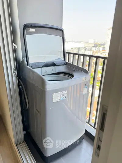 Modern washing machine on a balcony with city view, perfect for urban living convenience.