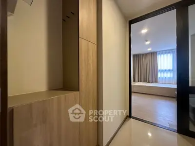 Modern apartment hallway leading to a cozy bedroom with wooden accents.