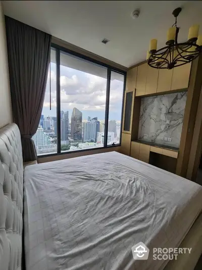 Luxurious bedroom with stunning city view and elegant chandelier in modern high-rise apartment.