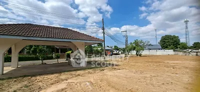 Spacious land plot with covered patio and clear blue sky, ideal for development.