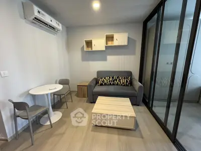 Modern living room with sleek furniture and glass partition in a stylish apartment.
